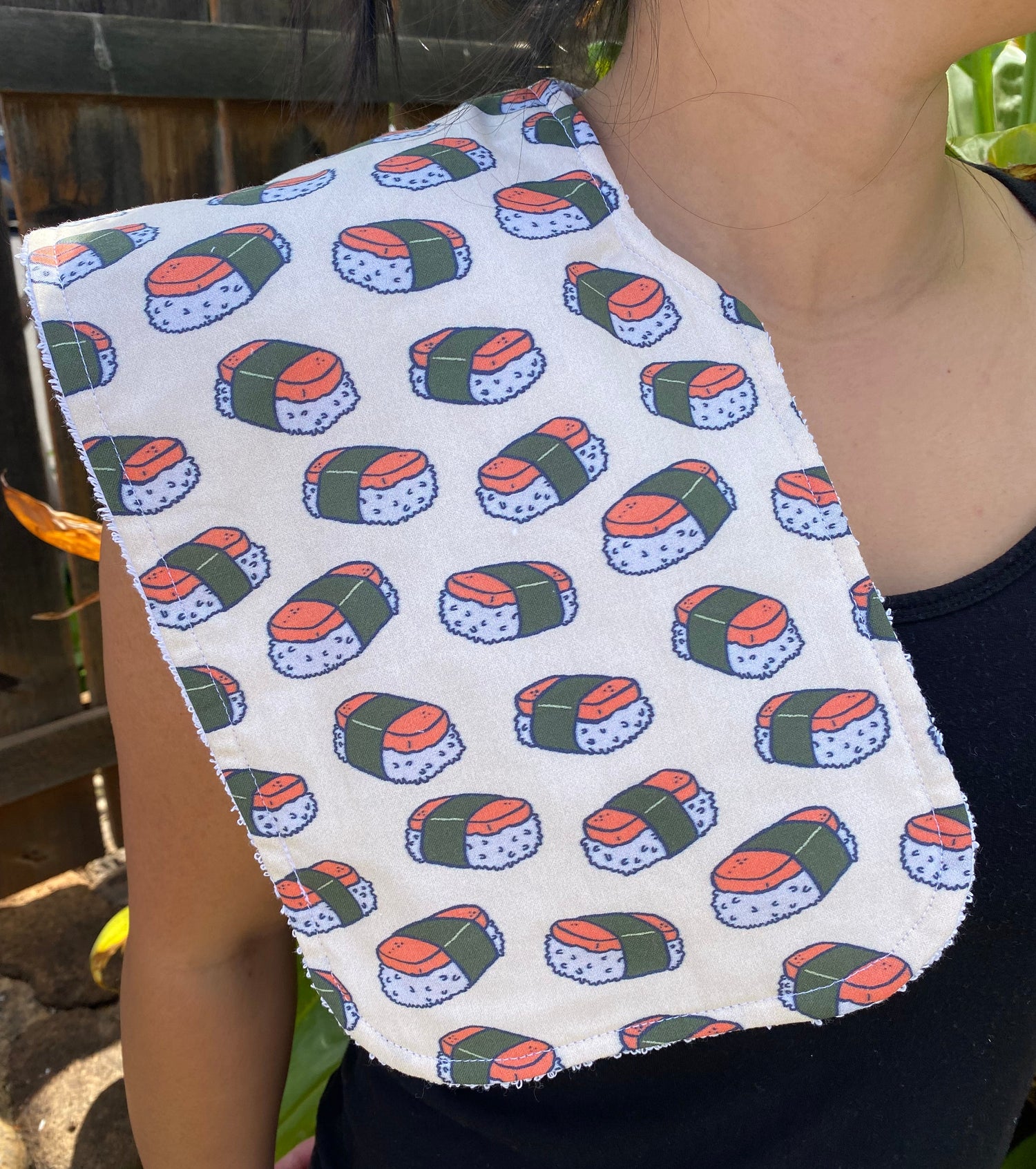 Handmade burpcloth in a musubi sushi pattern print fabric held by a person
